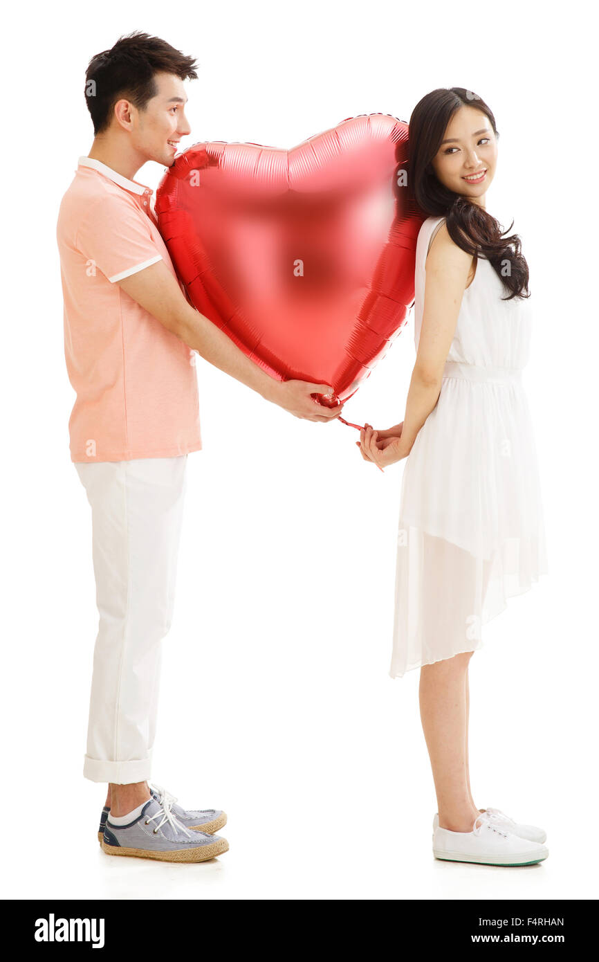 Happy couples holding a balloon Stock Photo - Alamy