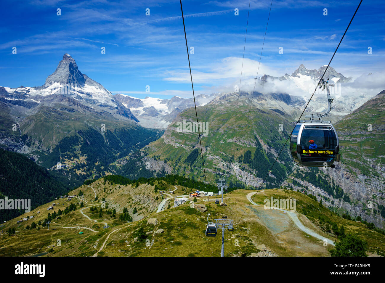 Cable cars sour past Matterhorn peak. July, 2105. Matterhorn, Switzerland. Stock Photo