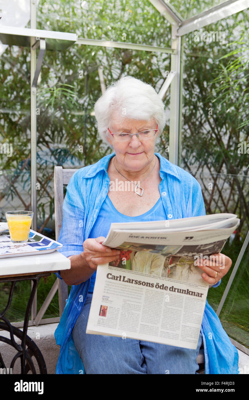 Woman reading newspaper in garden Stock Photo Alamy