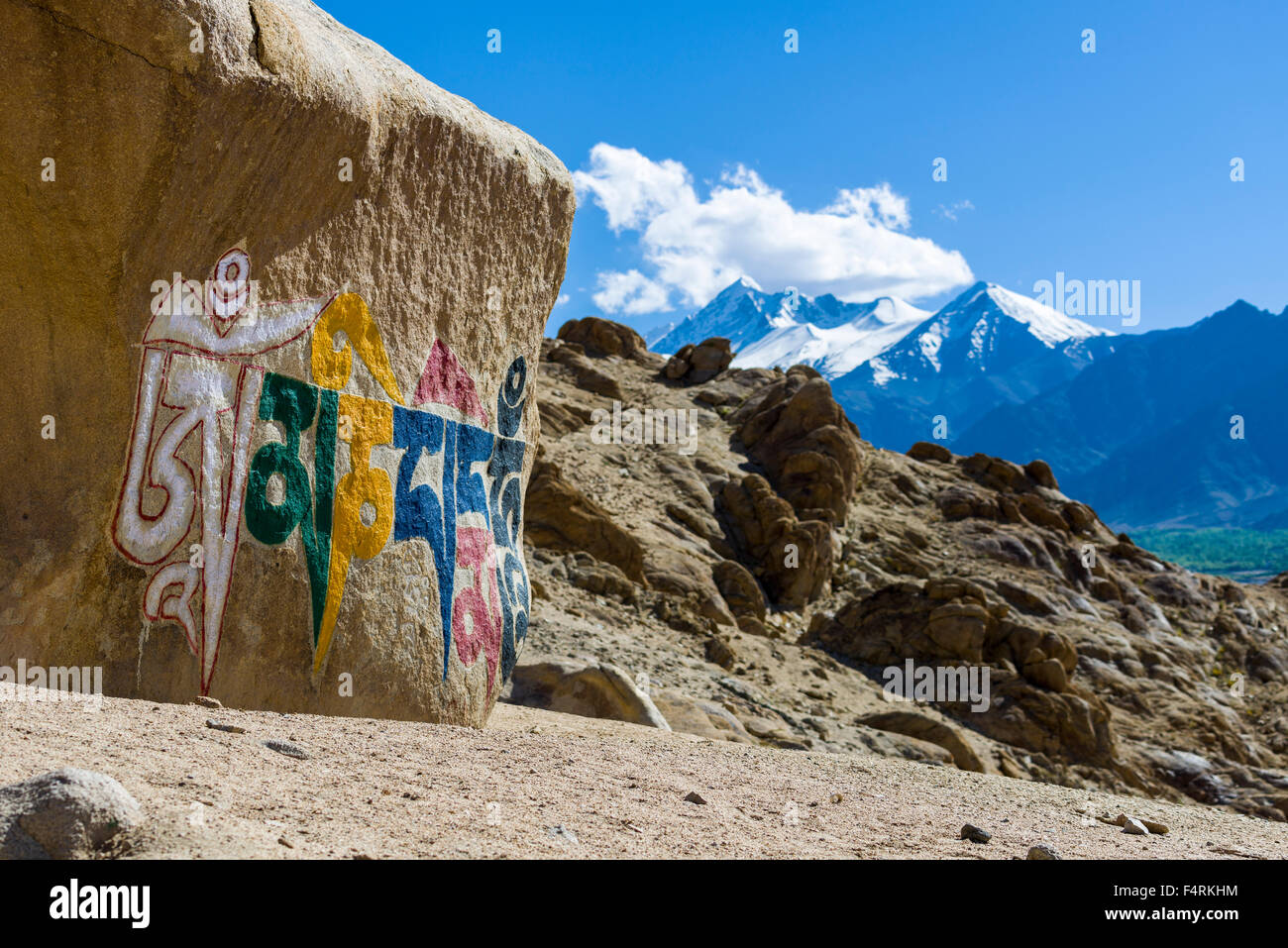 A big tibetean Mani Stone with the Mantra Om Mani Padme Hum colorfully engraved is located on a hill above the Indus Valley Stock Photo