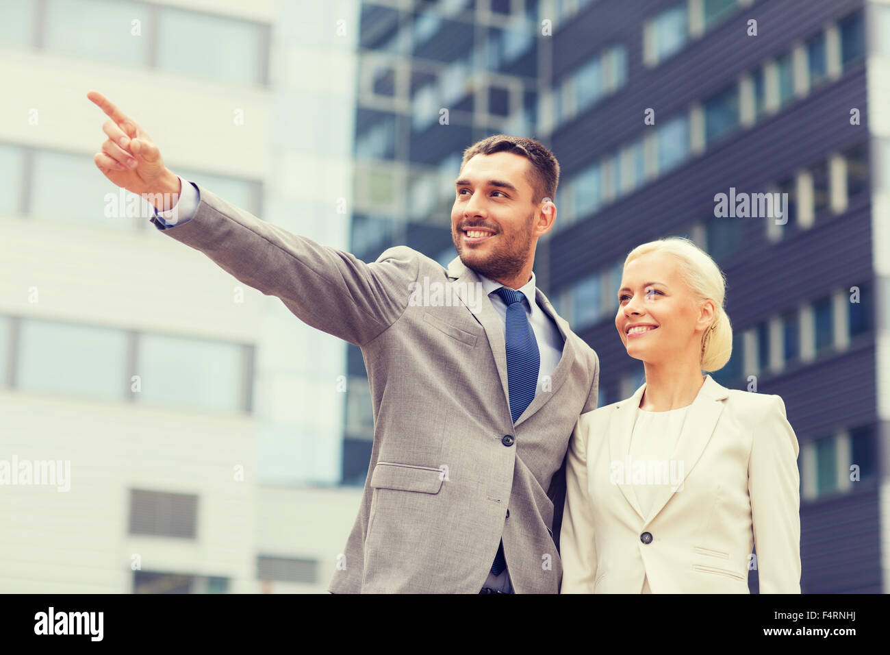 smiling businessmen standing over office building Stock Photo - Alamy