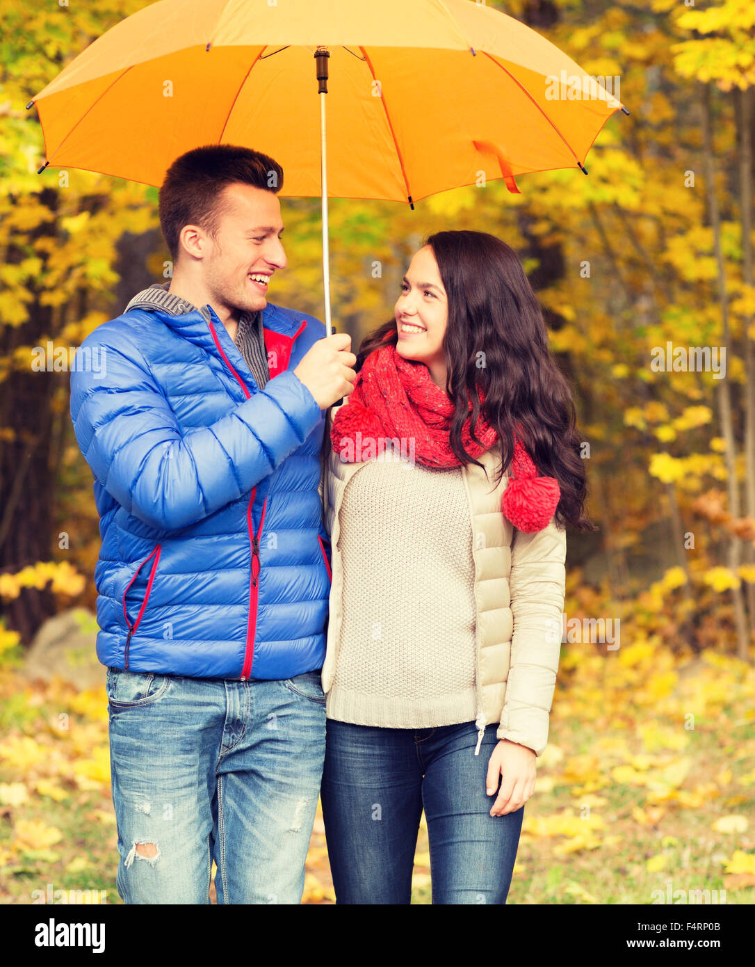 smiling couple with umbrella in autumn park Stock Photo - Alamy