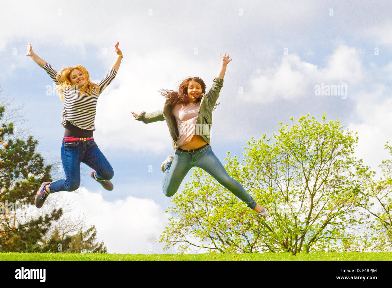 Tow happy girls in spring umping in the air Stock Photo