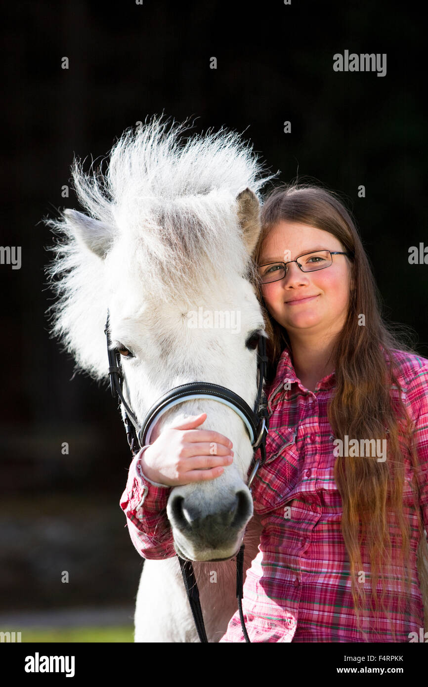 Girl cuddling with a pony, Schimmel, Austria Stock Photo