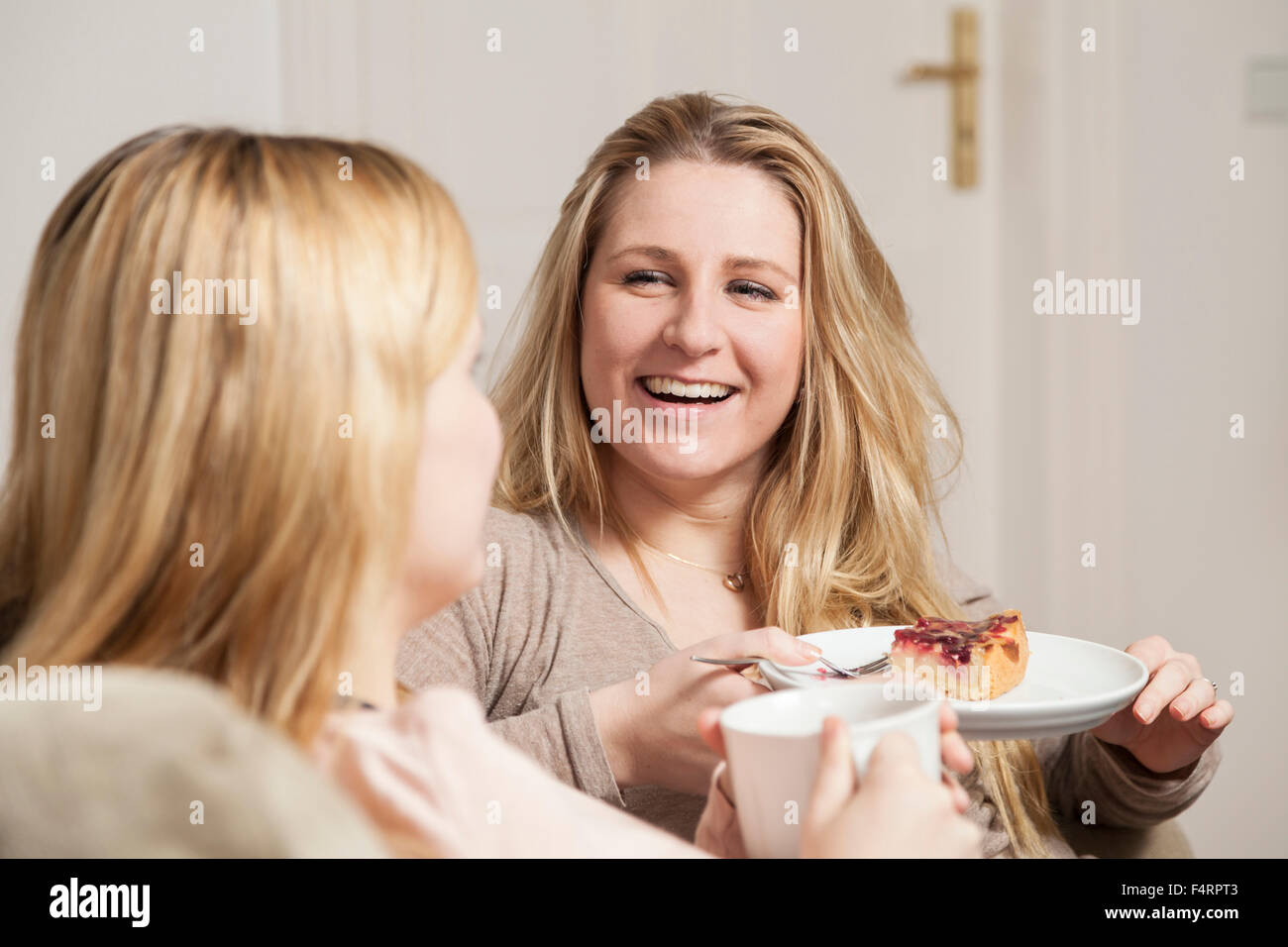 girlfriends in coffee gossip, one looks happy Stock Photo