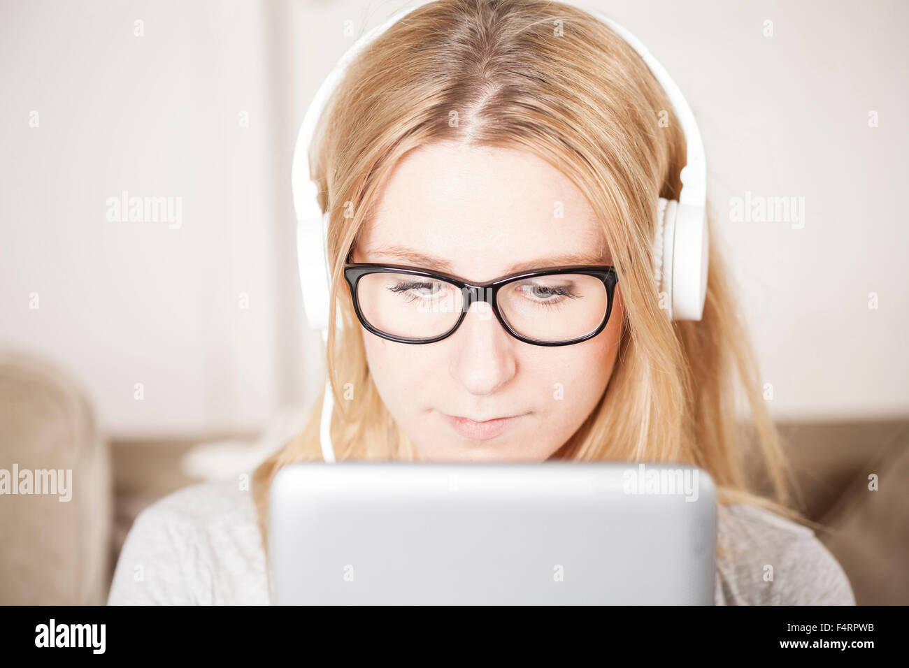 blond woman listening to music and looking at tablet computer Stock Photo