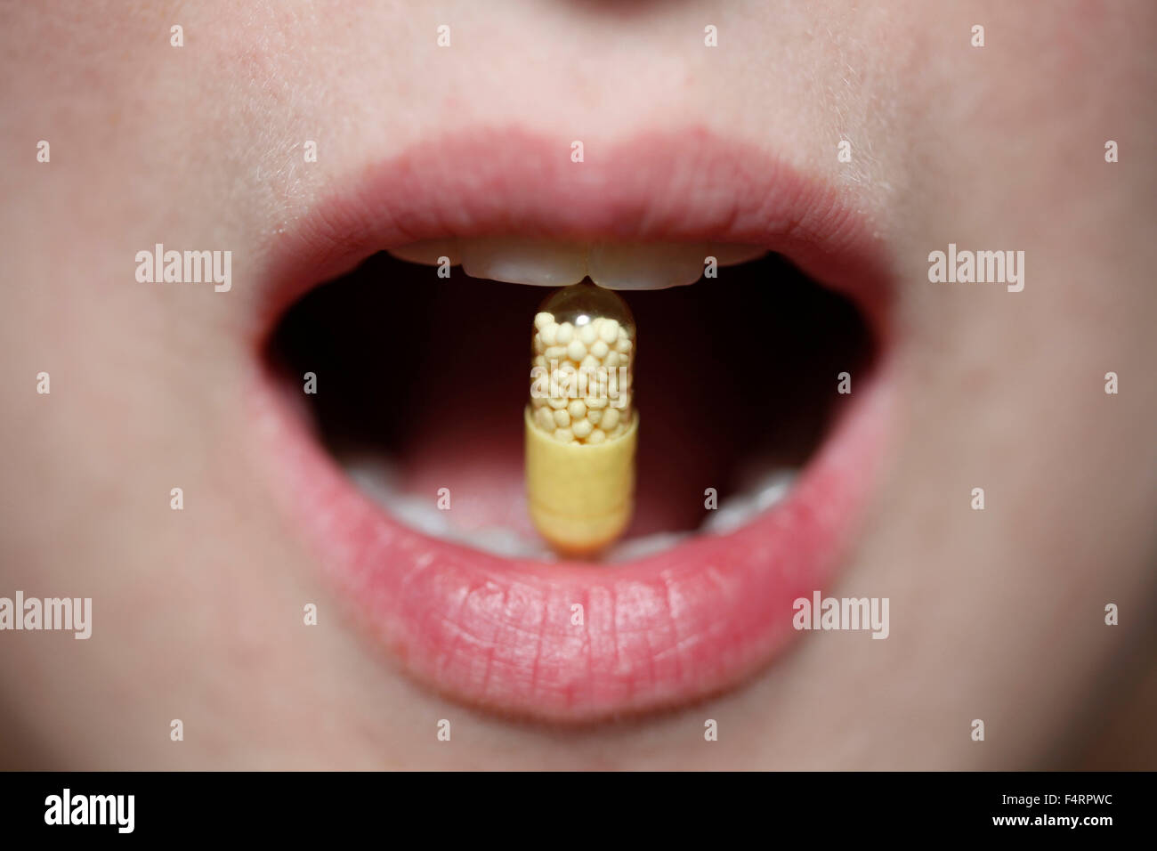 pill between teeht of woman mouth Stock Photo