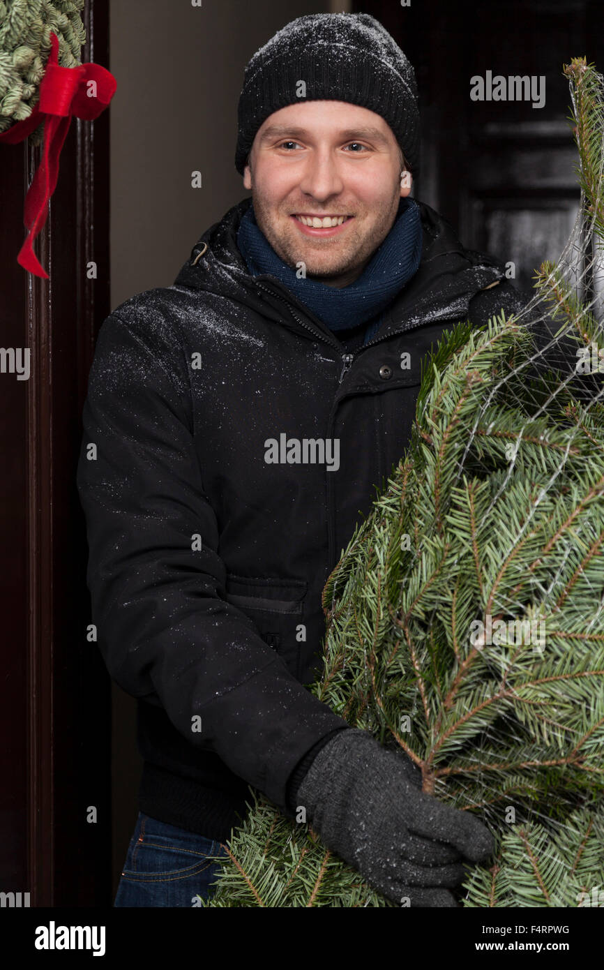 man holding a christmas tree Stock Photo