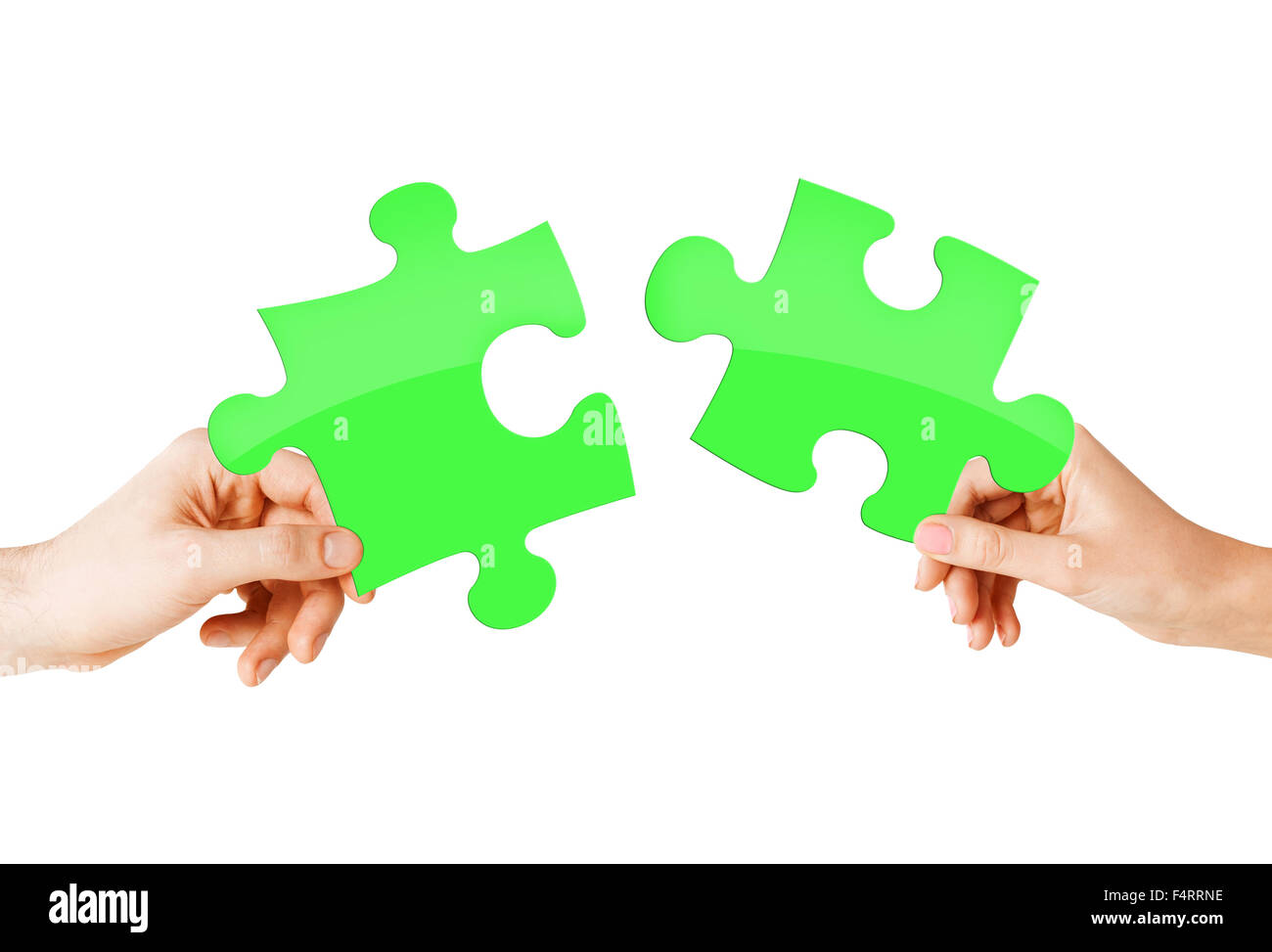 close up of couple hands with green puzzle pieces Stock Photo