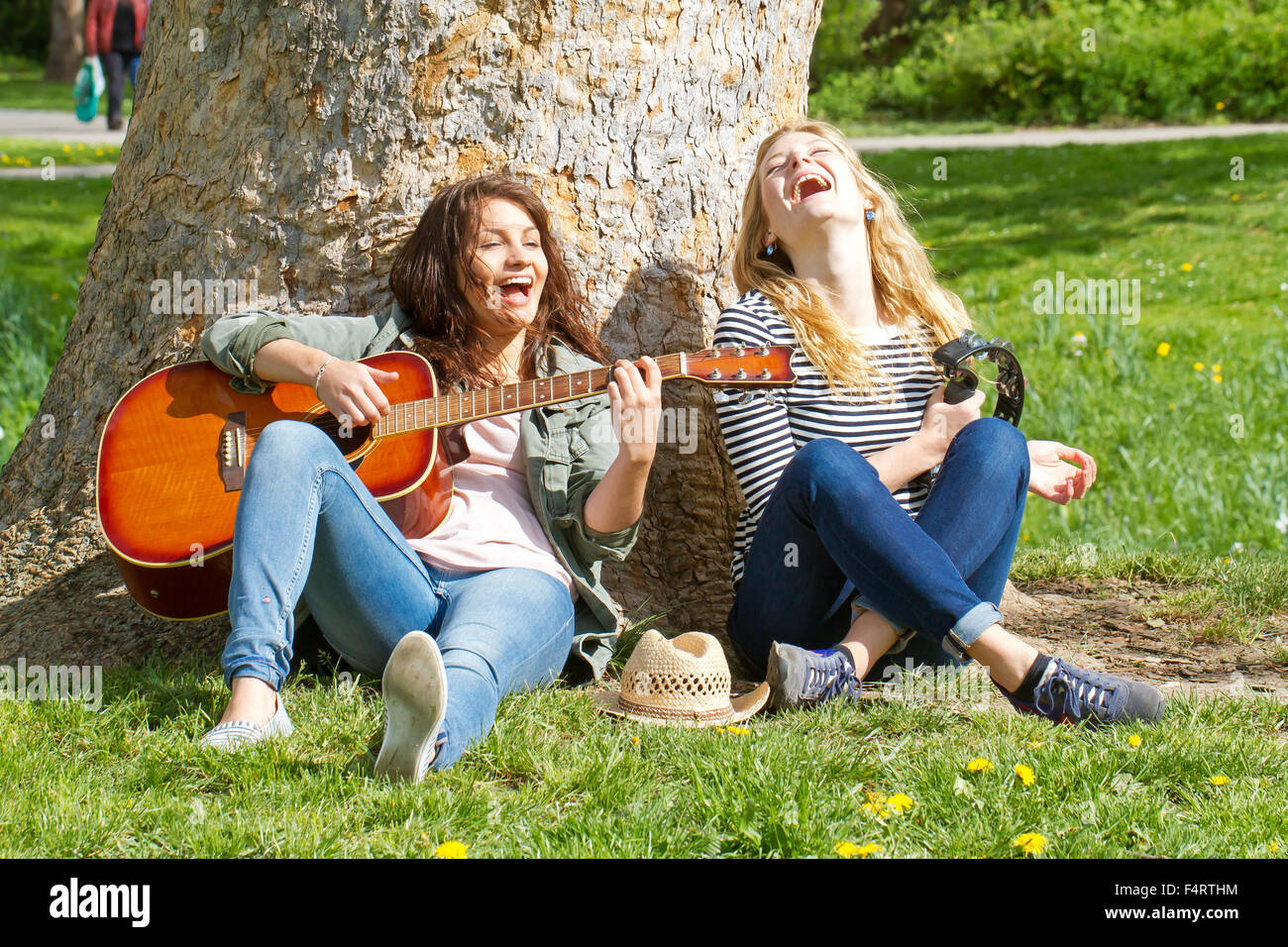 Two girls sitting in the park and making music Stock Photo