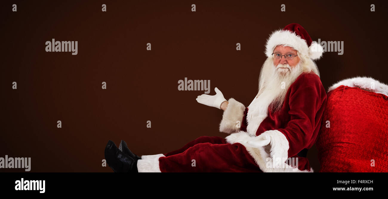 Composite image of santa sits leaned on his bag and has no clue Stock Photo