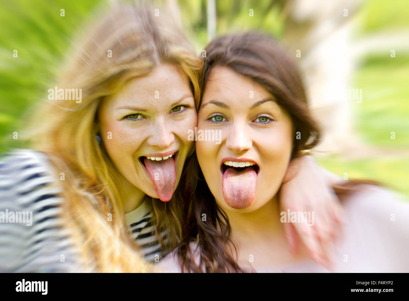 Two girls sticking tongue out Stock Photo