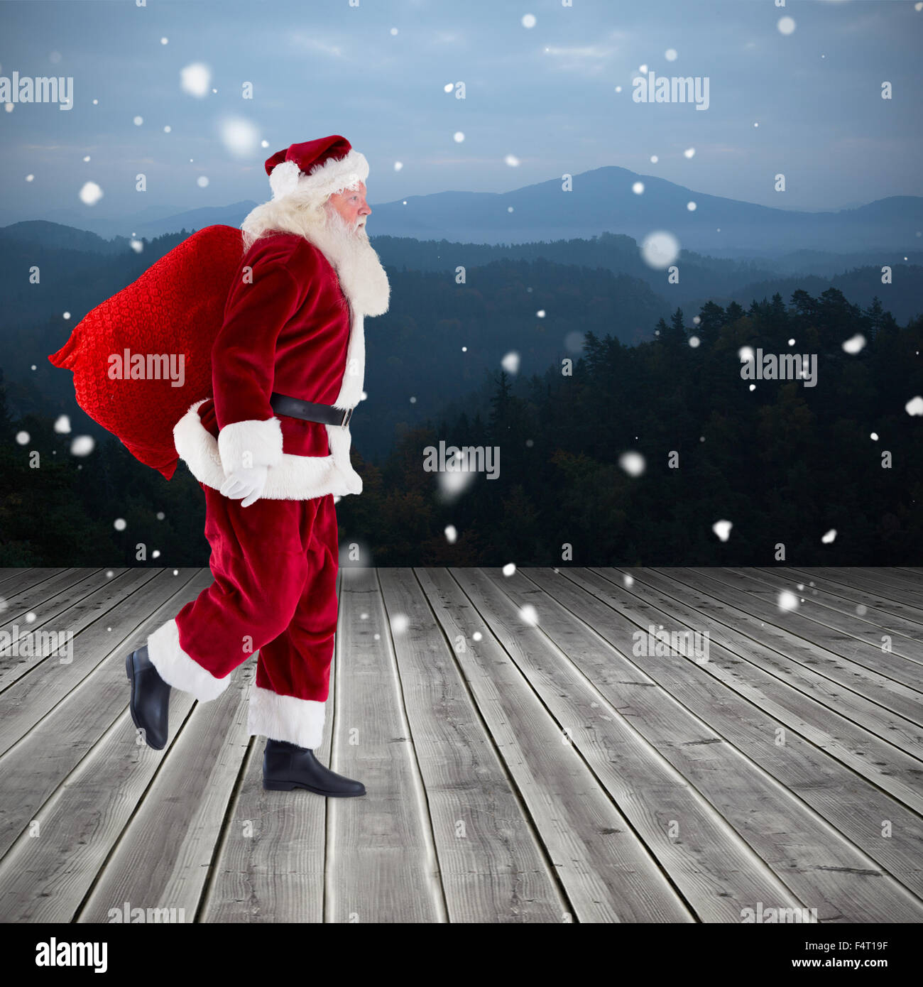 Composite image of santa carrying sack of gifts Stock Photo - Alamy