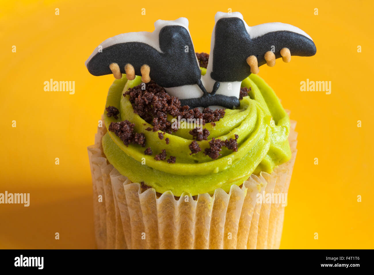 M&S Toffee Apple cupcake with witches feet for Halloween on yellow plate Stock Photo