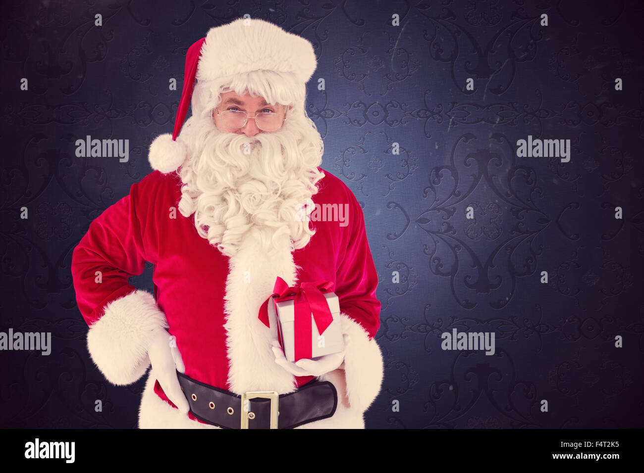 Composite image of happy santa claus holding a gift Stock Photo - Alamy