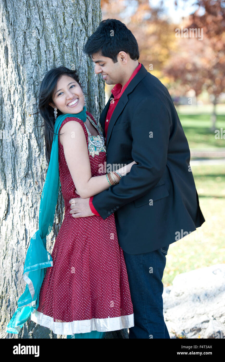 A young and happy Indian couple looking at each other in the fall near ...