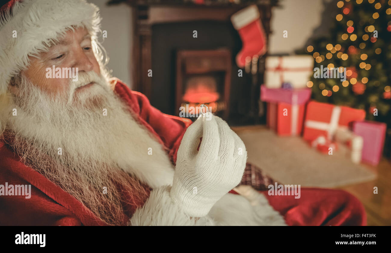 Santa claus holding engagement ring Stock Photo - Alamy