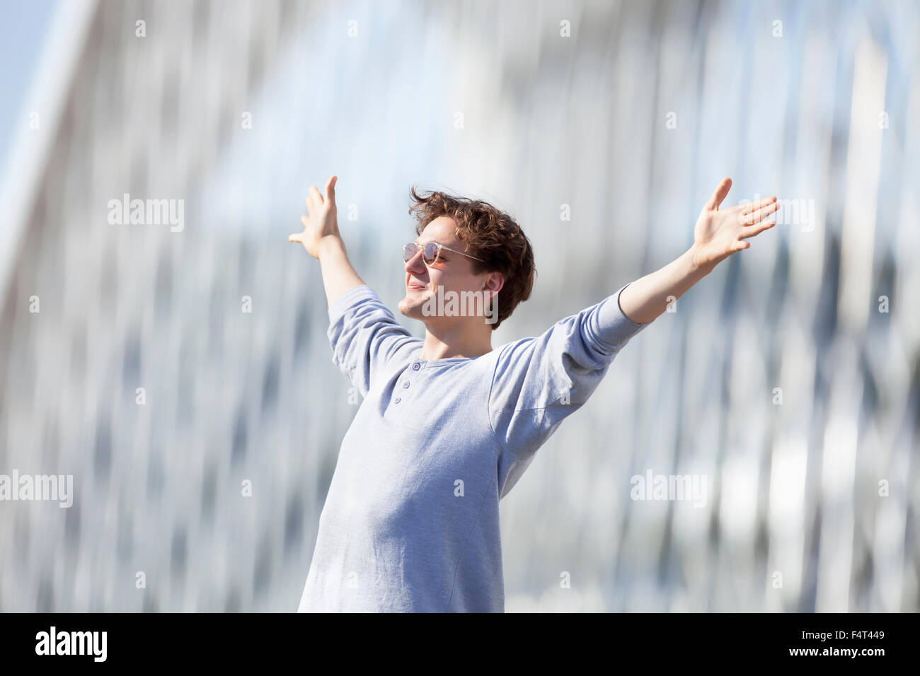 Excited Young Man Stretching out his Arm in Emotion Outdoors Stock Photo