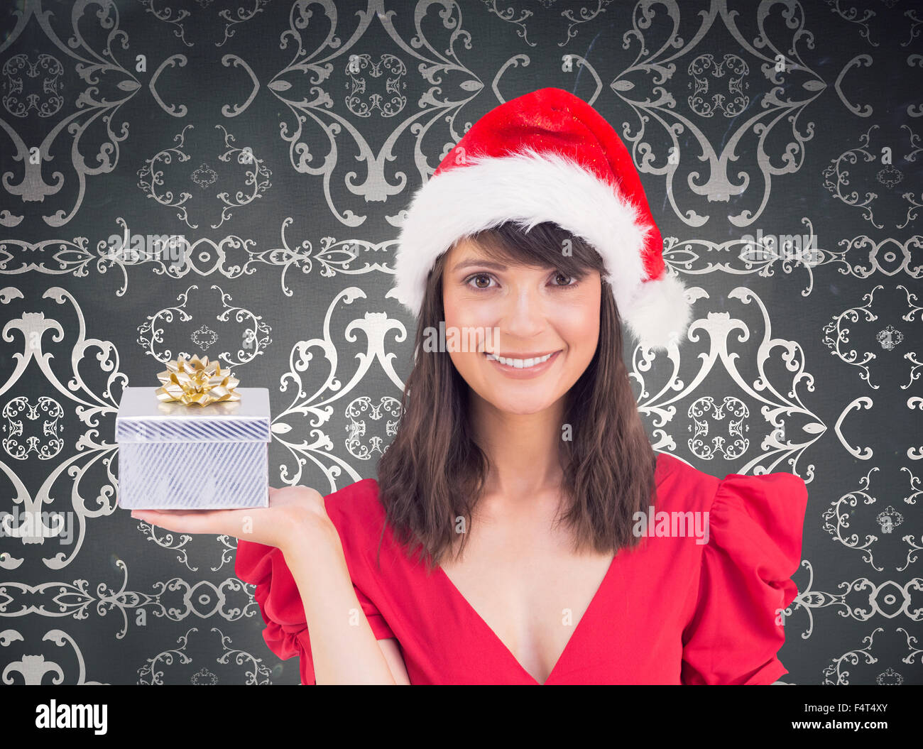 Composite image of festive brunette holding a gift Stock Photo