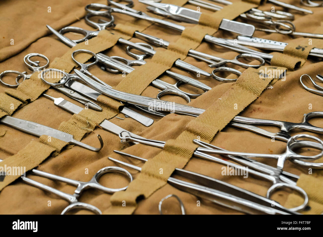 Large selection of stainless steel surgical equipment, including Magill and artery forceps, tweezers, retractors in canvas roll Stock Photo