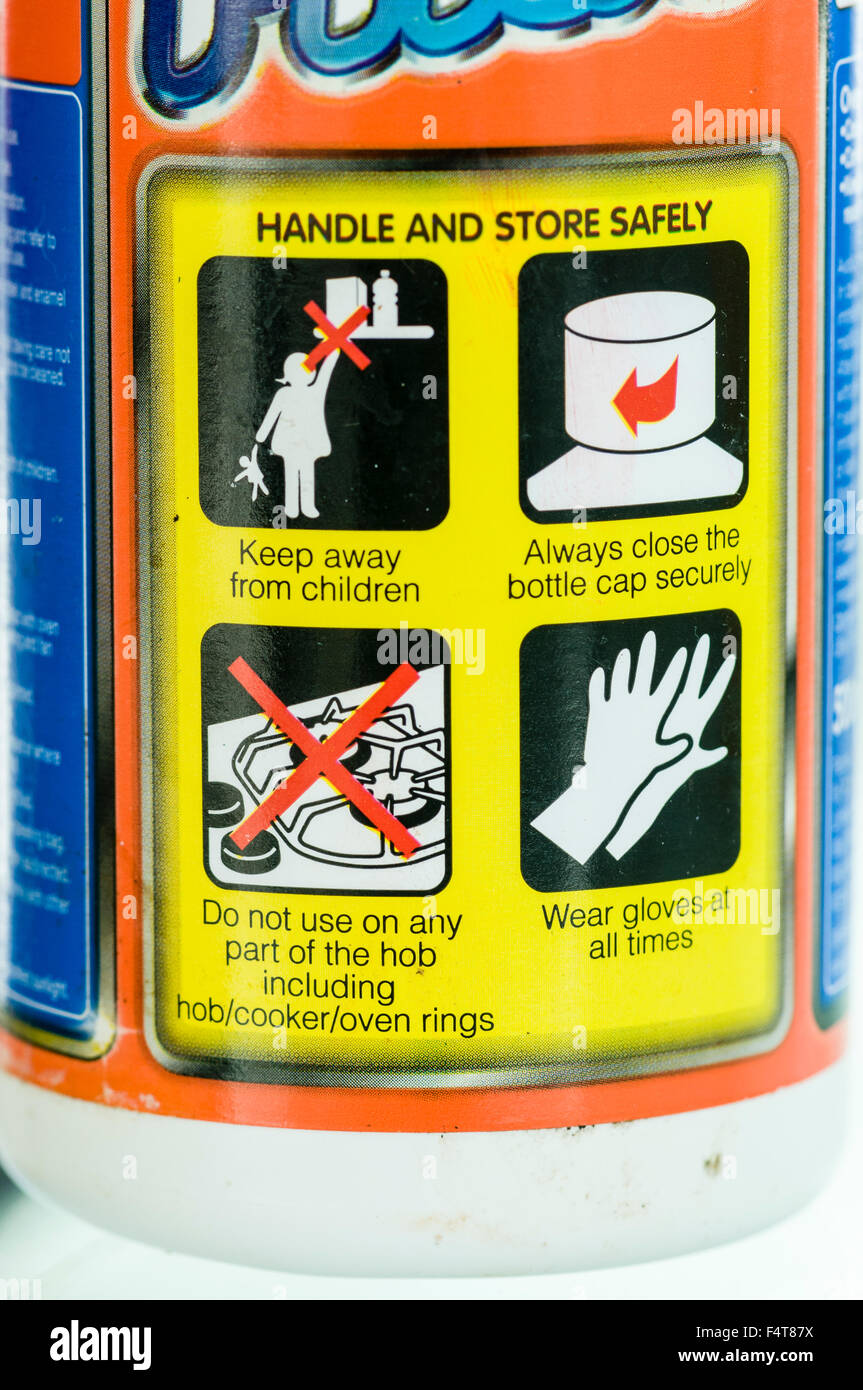 Warnings on a cleaning product to keep product away from children, to close the cap securely, not to use on hobs, and to wear gloves Stock Photo