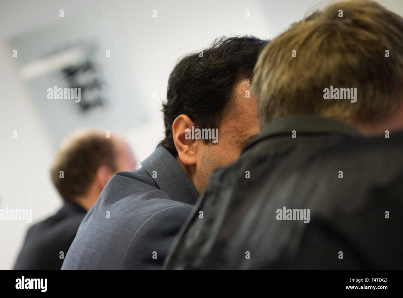 Stuttgart, Germany. 22nd Oct, 2015. The plaintiff (2-R) talks to his attorney in a courtroom of the administrative court in Stuttgart, Germany, 22 October 2015. The plaintiff questions the legitimacy of a check by German police in a train. Photo: MARIJAN MURAT/dpa/Alamy Live News Stock Photo