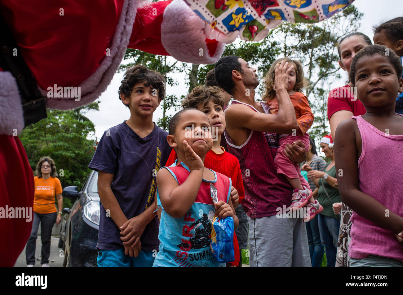 Man dresses up as Santa Claus for visiting poor districts and distributing gifts to children at Christmas. Nova Friburgo city, Rio de Janeiro state, Brazil. Stock Photo
