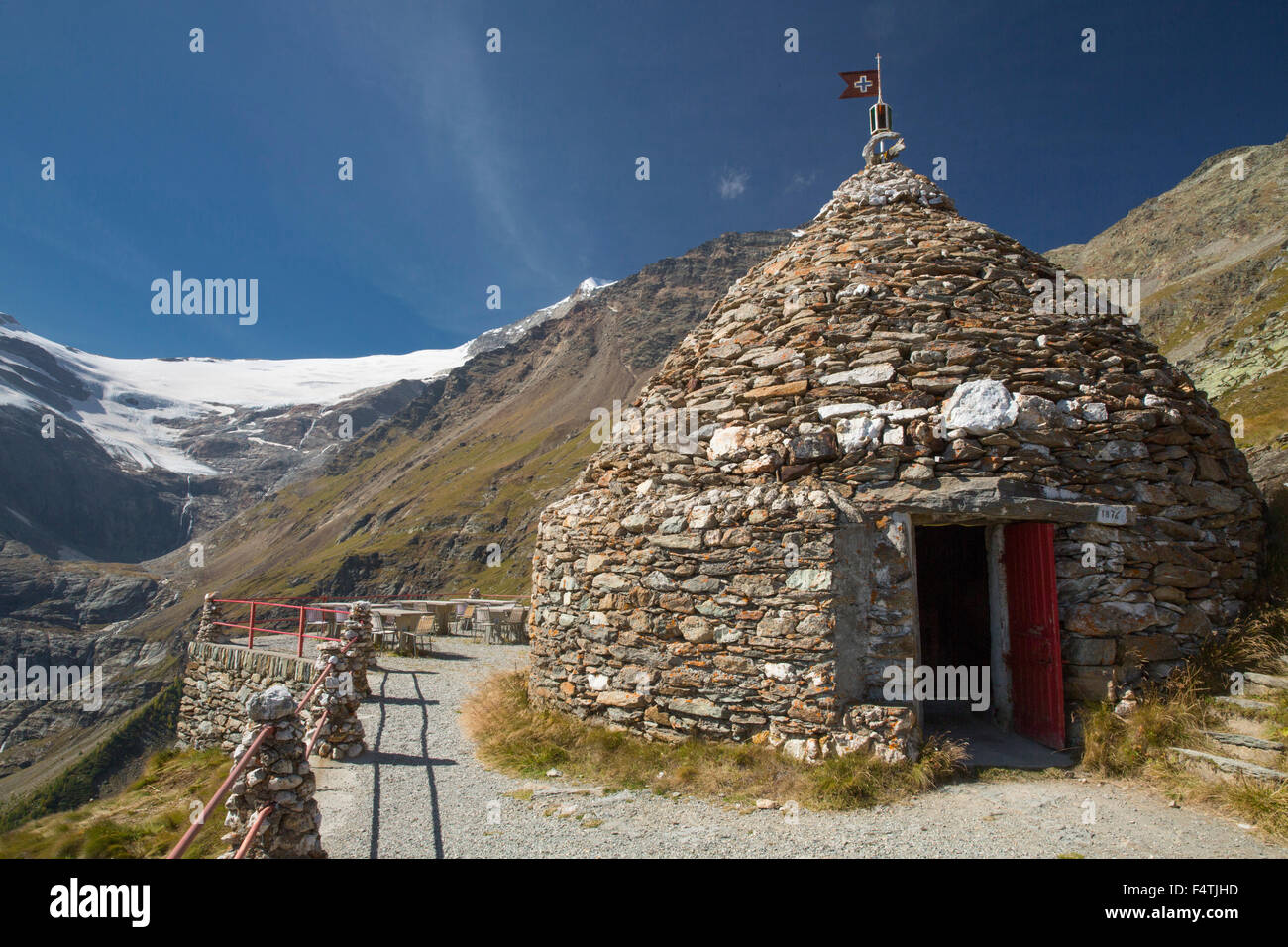 Stone huts near Sassal Mason in Posciavo in front of Palü glacier, Stock Photo