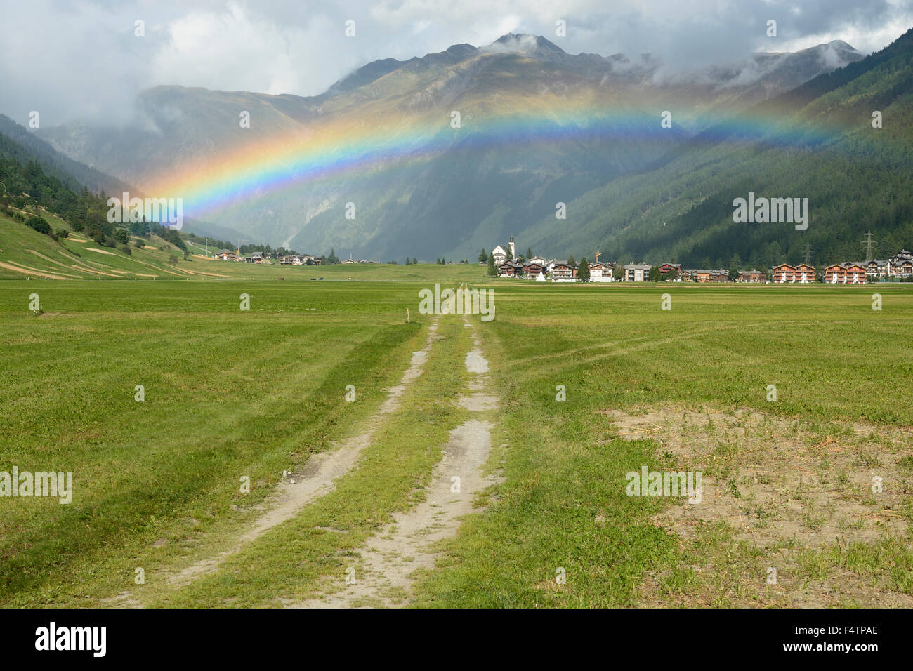 Obergesteln, village, pastures, rainbow, Obergoms, Canton of Valais, Switzerland Stock Photo