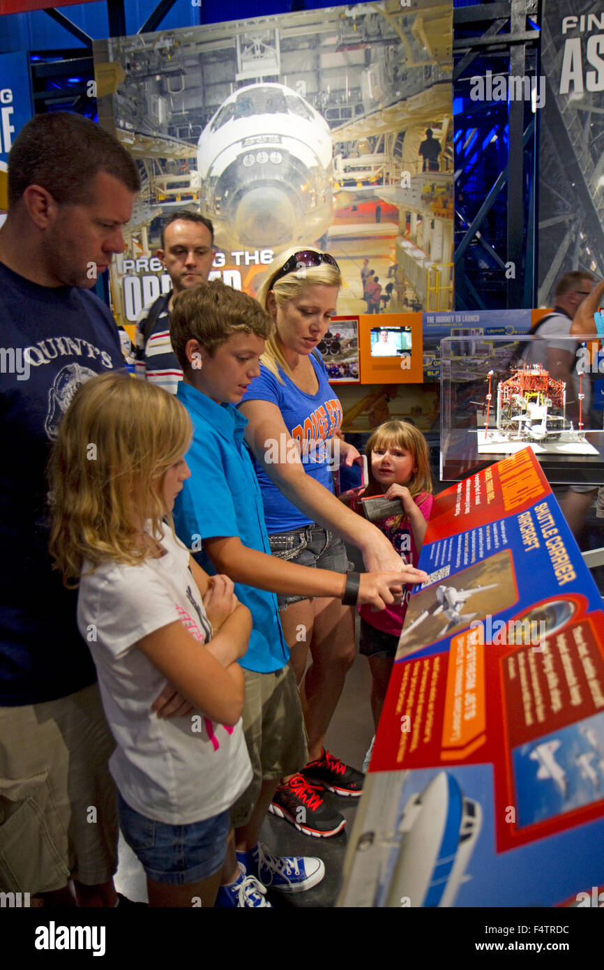 Tourists reading a display at the John F. Kennedy Space Center, Merritt Island, Florida, USA. Stock Photo