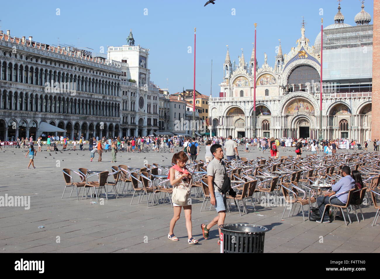 Tourists stroll around San Marco's Square, with the church in the background Stock Photo