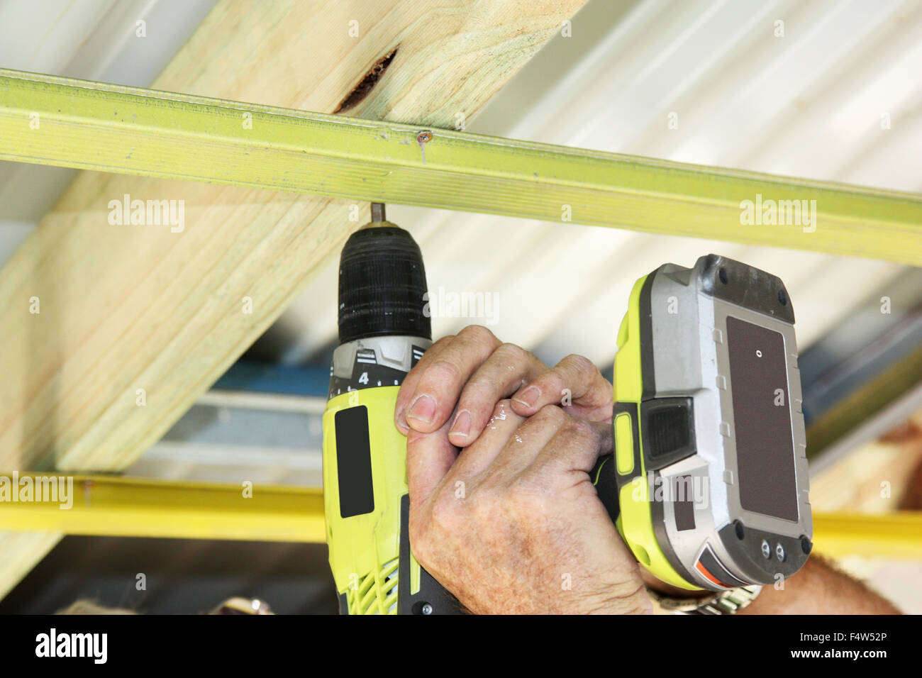 A Cordless Hand Drill Used To Put Ceiling Battens On Stock Photo
