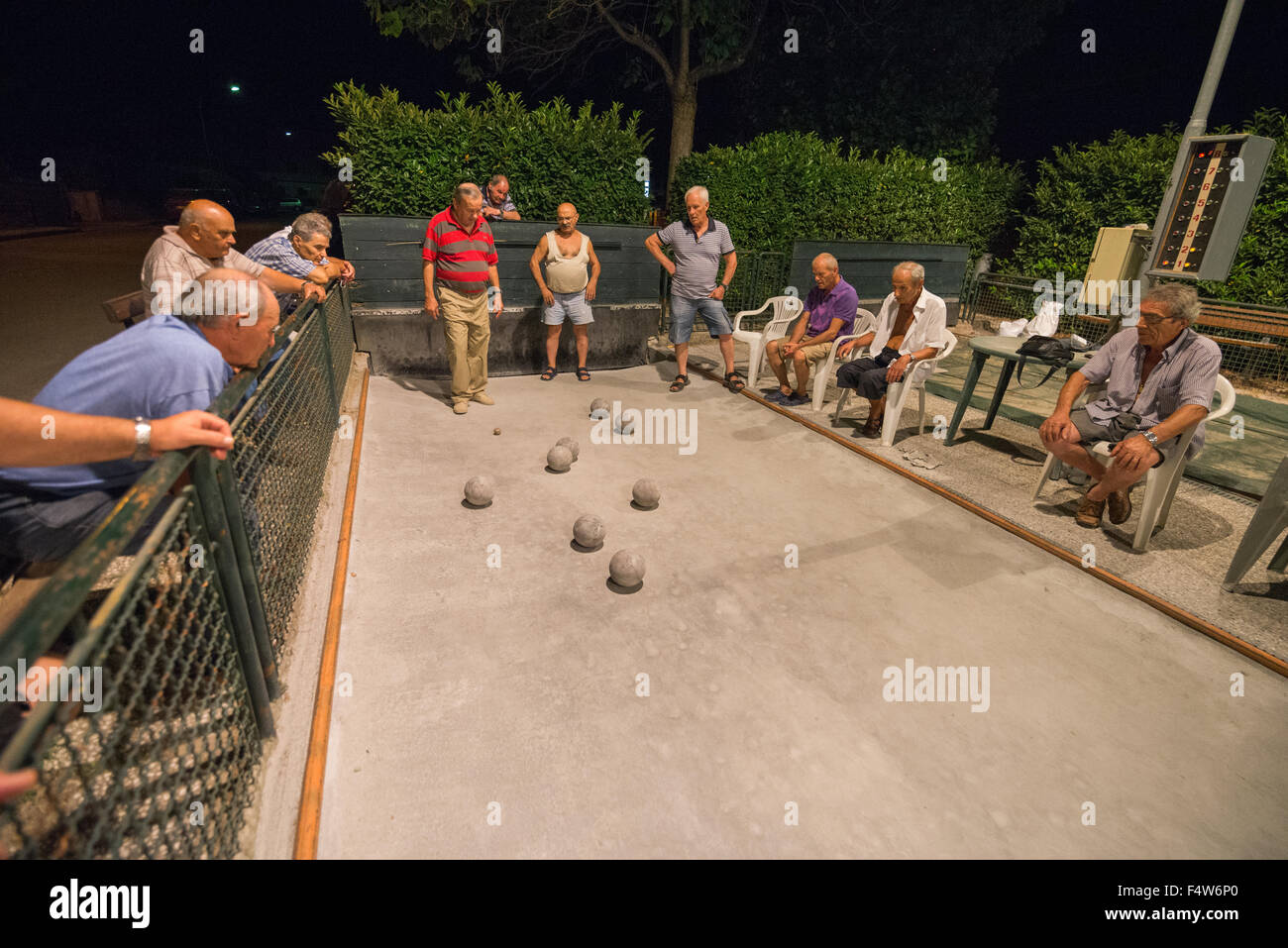 Local men being played bocce ball on outdoor court in Colle di Val d'Elsa, Tuscany, Italy. Stock Photo