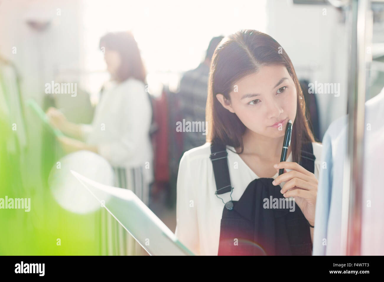 Pensive fashion designer examining shirt Stock Photo