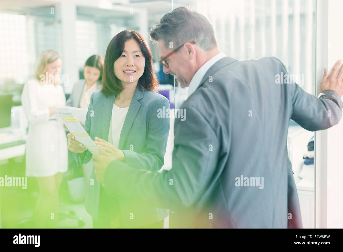 Business people discussing paperwork in office Stock Photo - Alamy