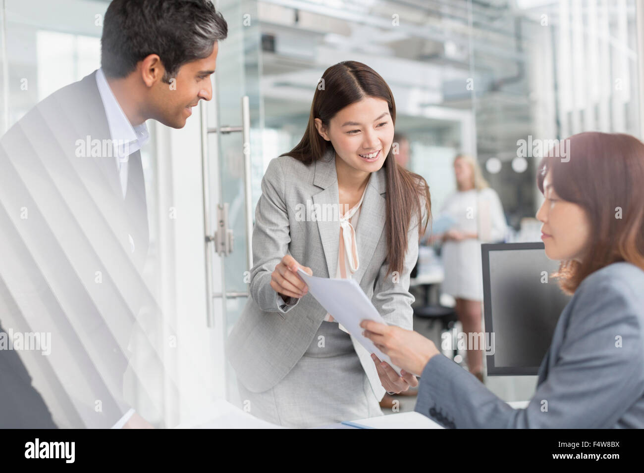 Business people discussing paperwork in office Stock Photo - Alamy