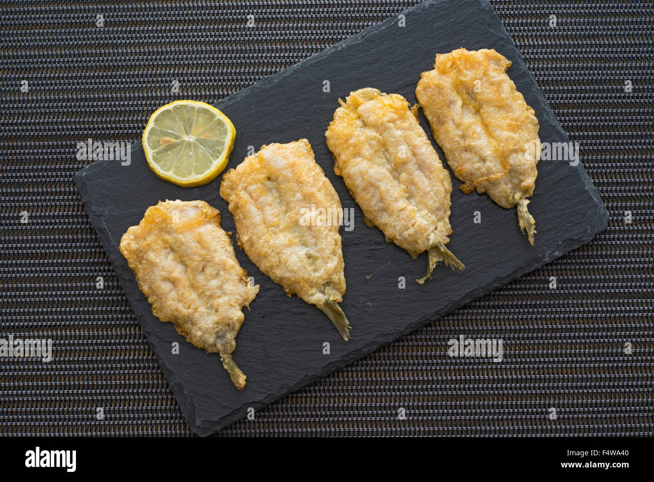 fritters of battered anchovies with lemon Stock Photo