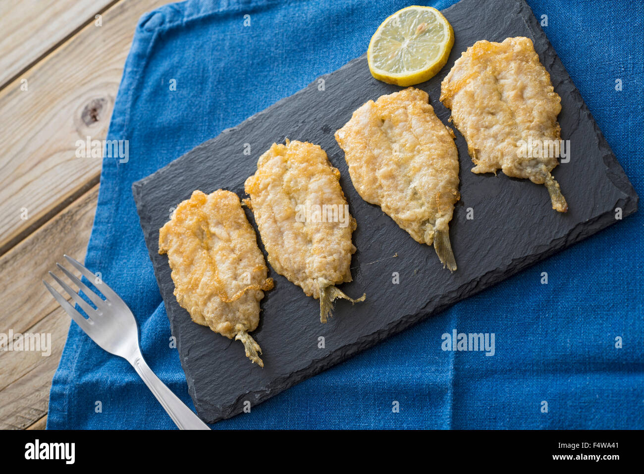 fritters of battered anchovies with lemon Stock Photo