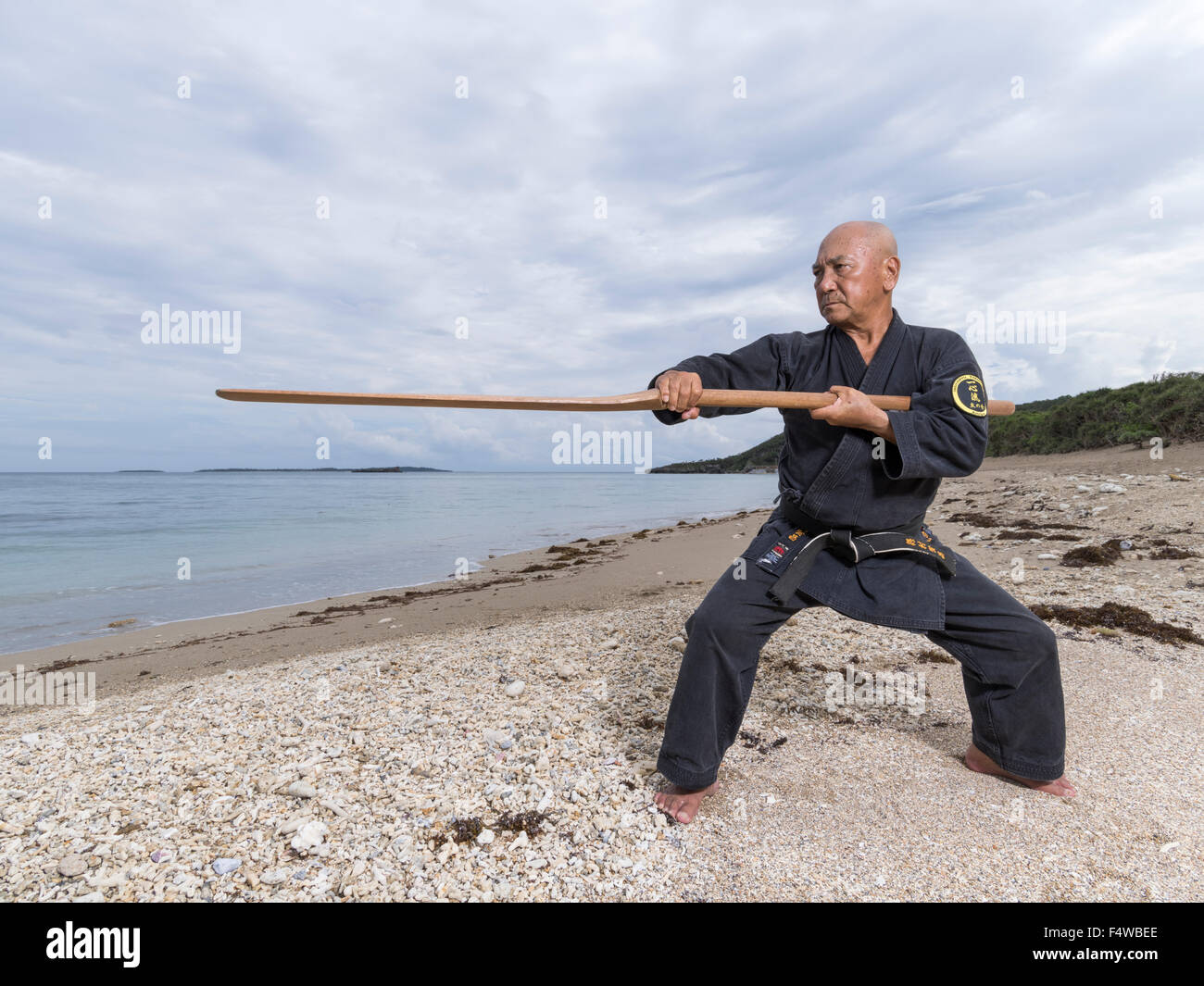 Kensho Tokumura, Hanshi 9th-dan Ryukyu Dento Kobujutsu Hozon Budo Kyokai Training on Heshikiya Beach, Katsuren, Okinawa. 德村 賢昌　 Stock Photo