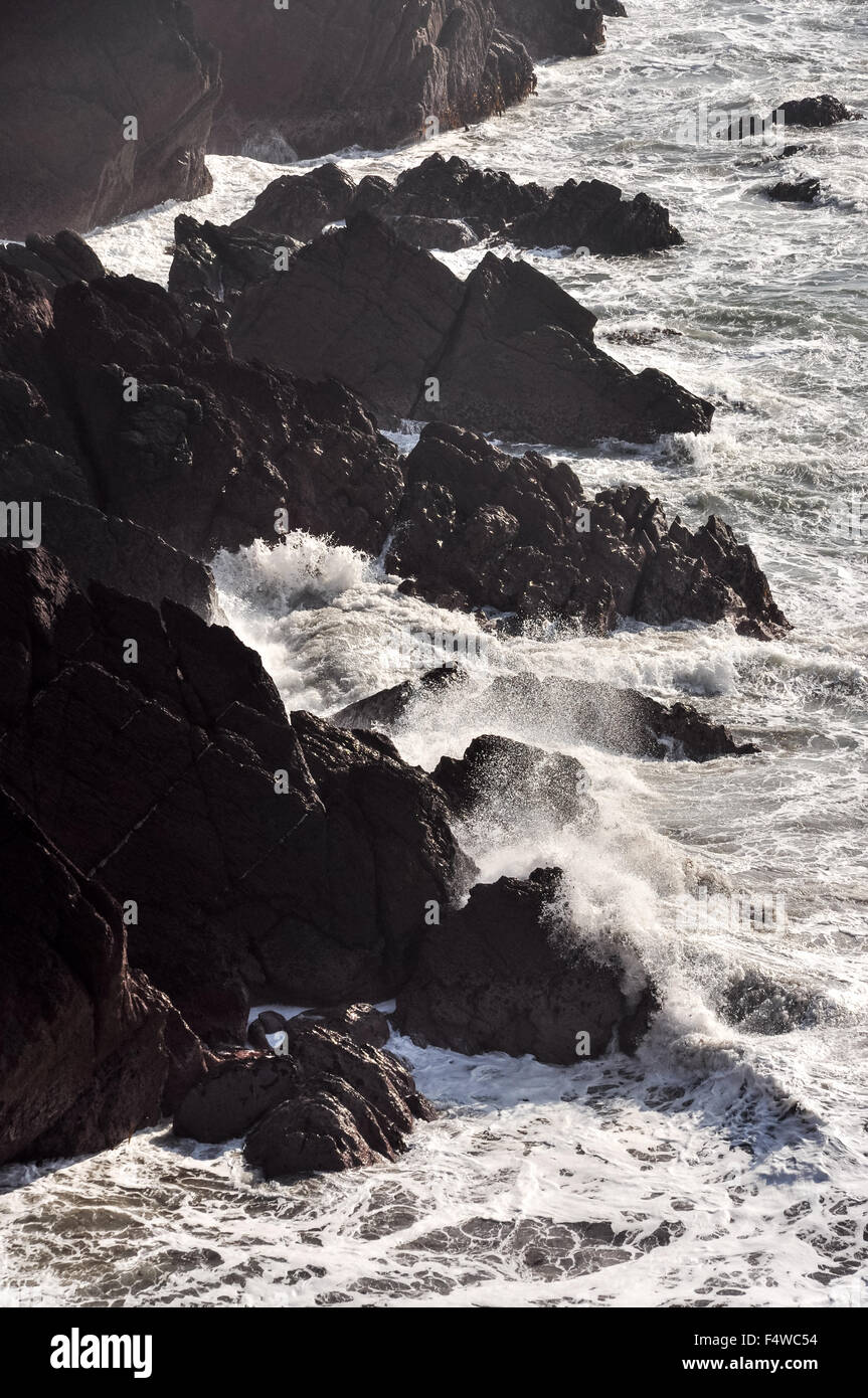 Energetic waves crashing on rocks at St Annes Head in Pembrokeshire, Wales. Stock Photo