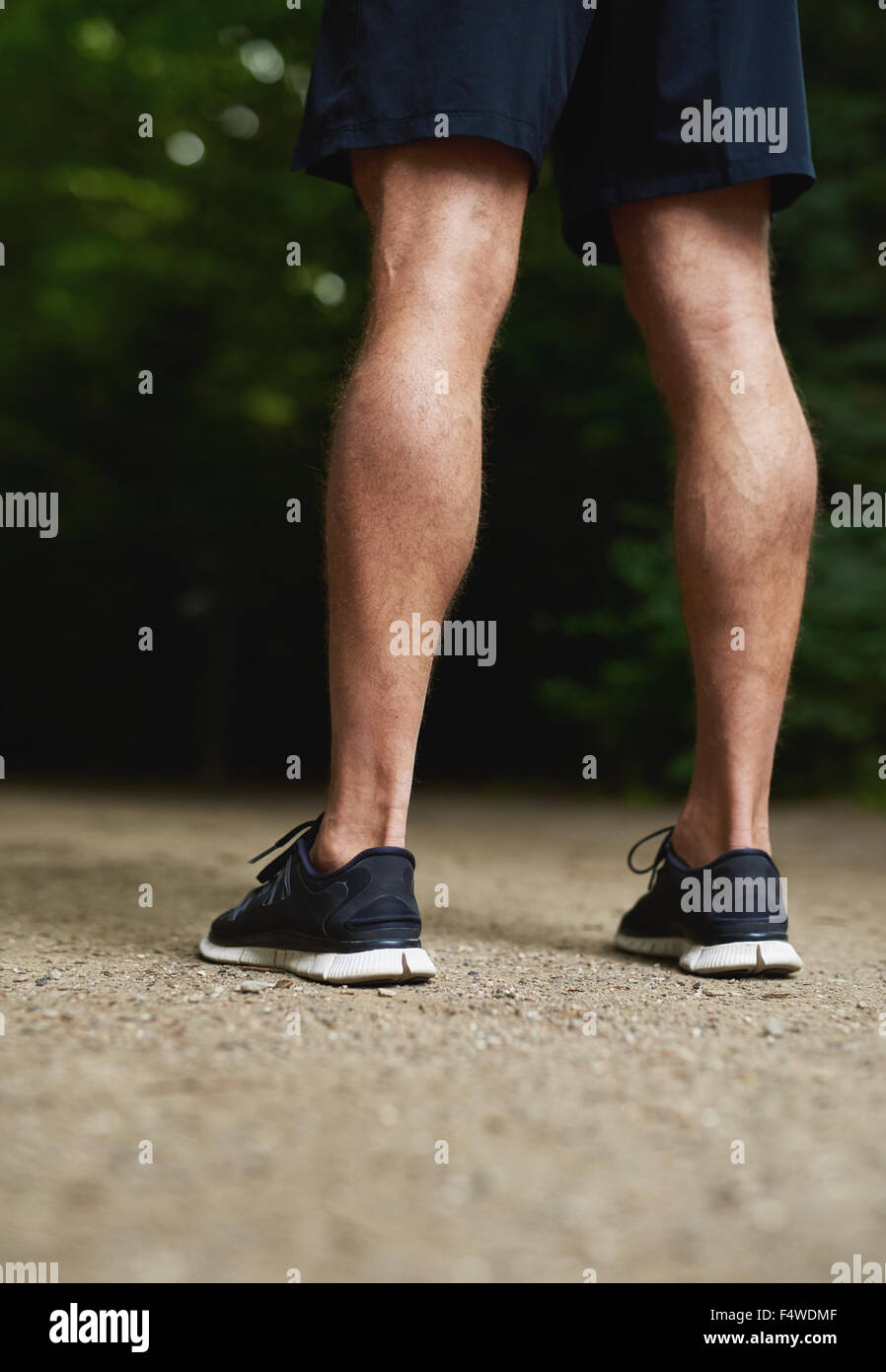 Rear view of the legs of a fit muscular athletic man with toned calves standing outdoors in his sportswear Stock Photo