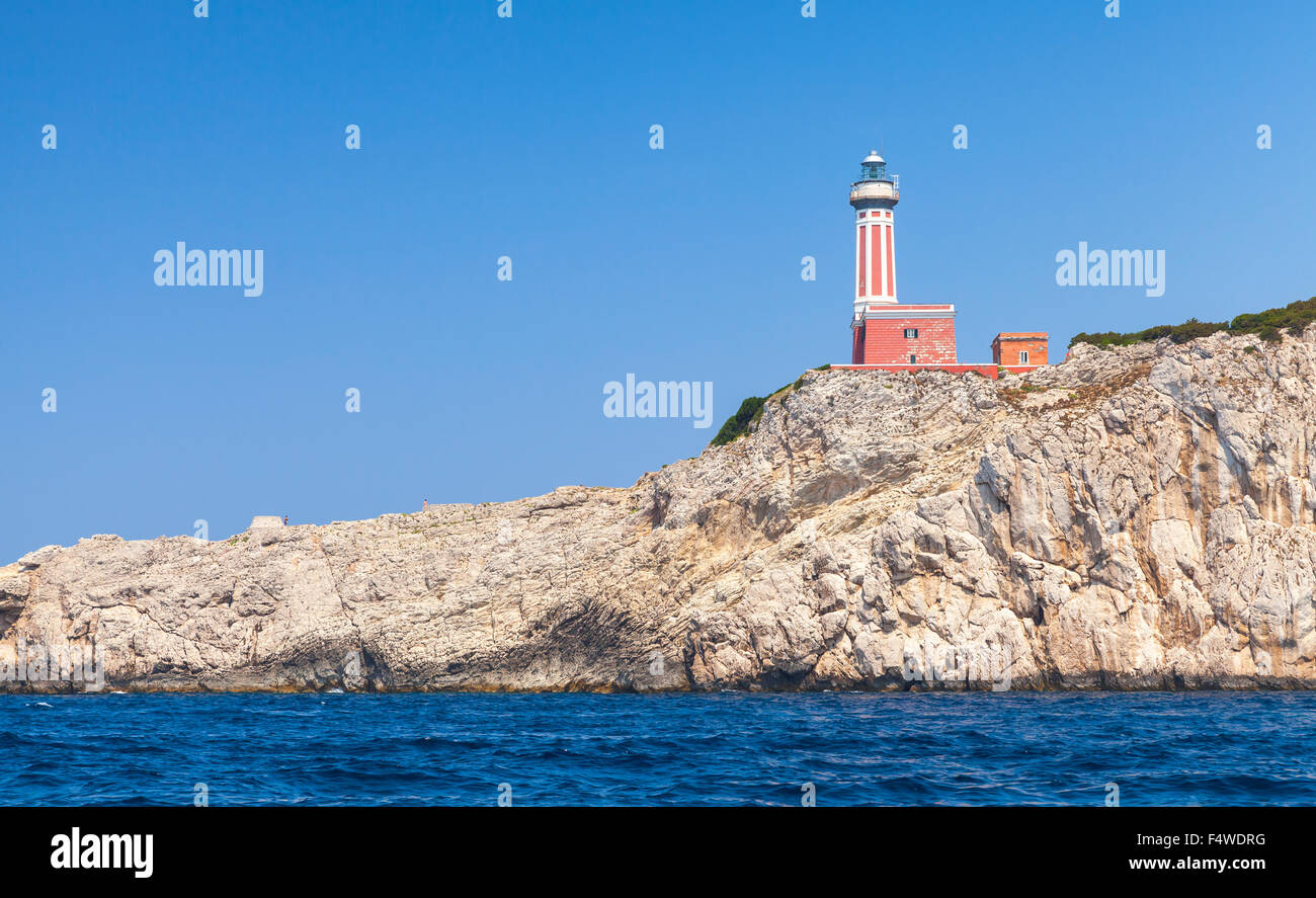 Punta Carena. Red lighthouse tower stands on the rocky coast of Capri ...
