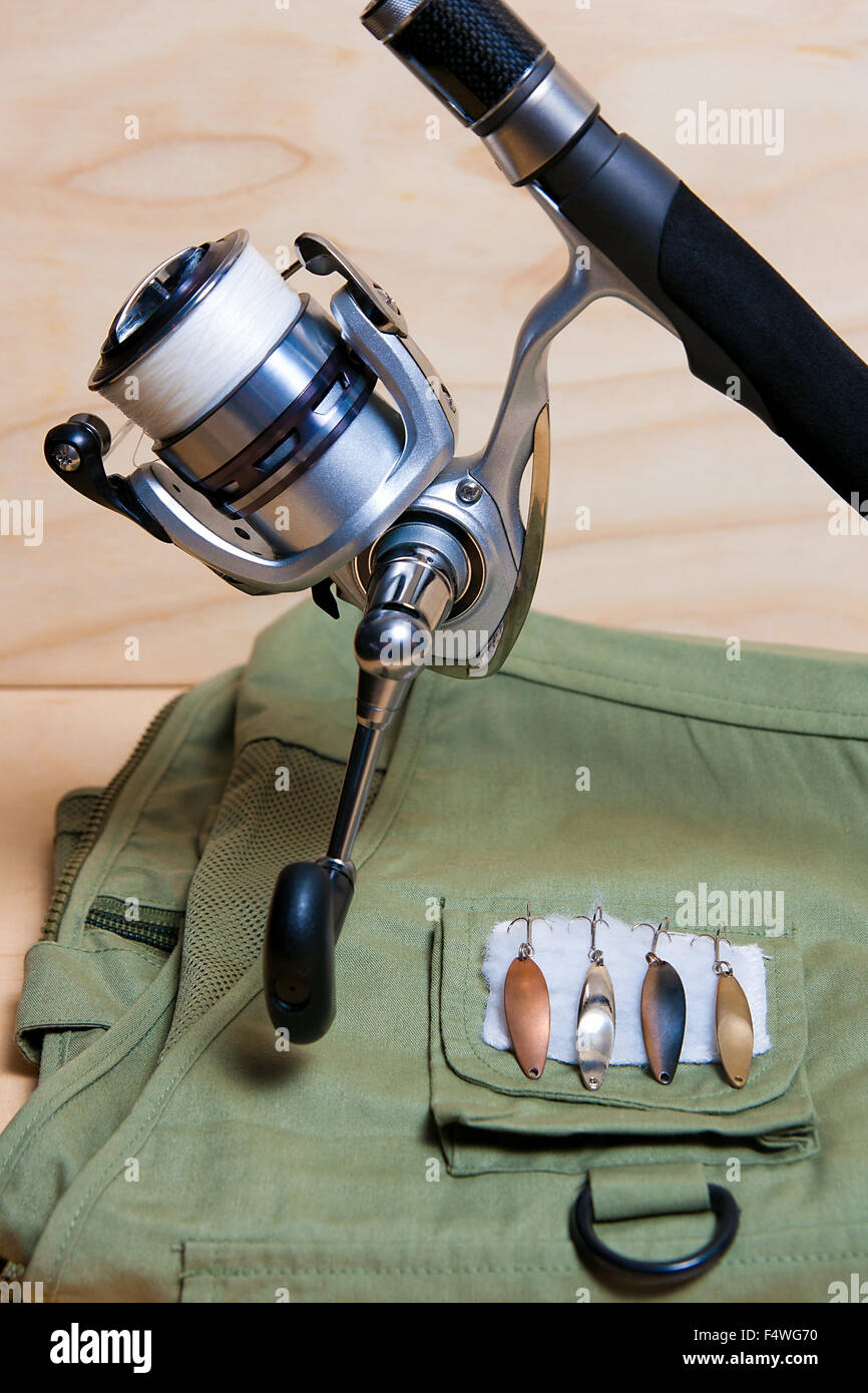 Fishing rod and reel with fishing vest and lures. Stock Photo