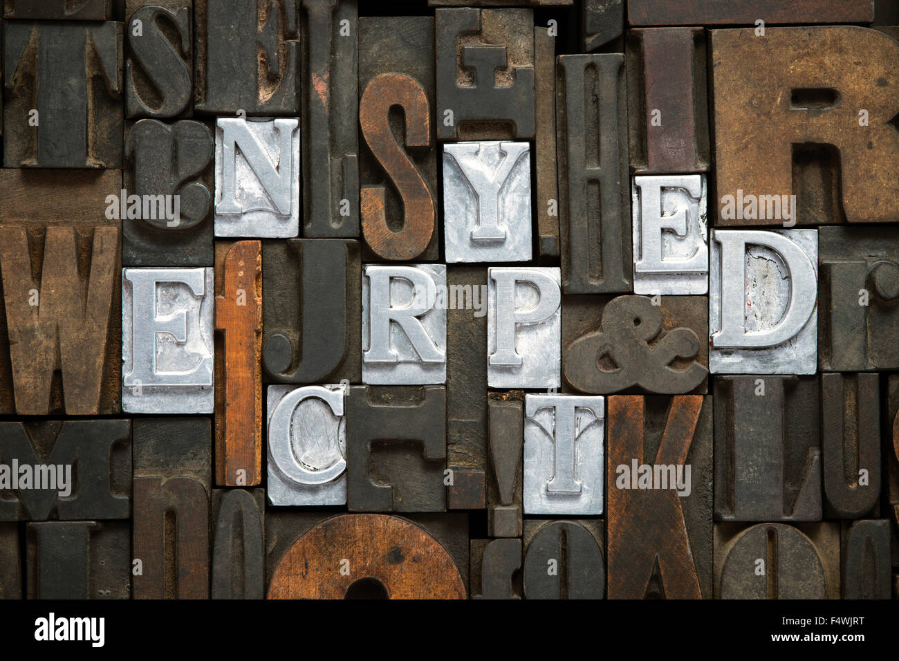 encrypted concept made from metallic letterpress blocks in mixed wooden letters Stock Photo