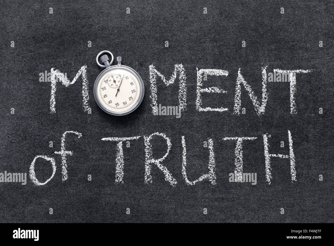 moment of truth phrase handwritten on chalkboard with vintage precise stopwatch used instead of O Stock Photo