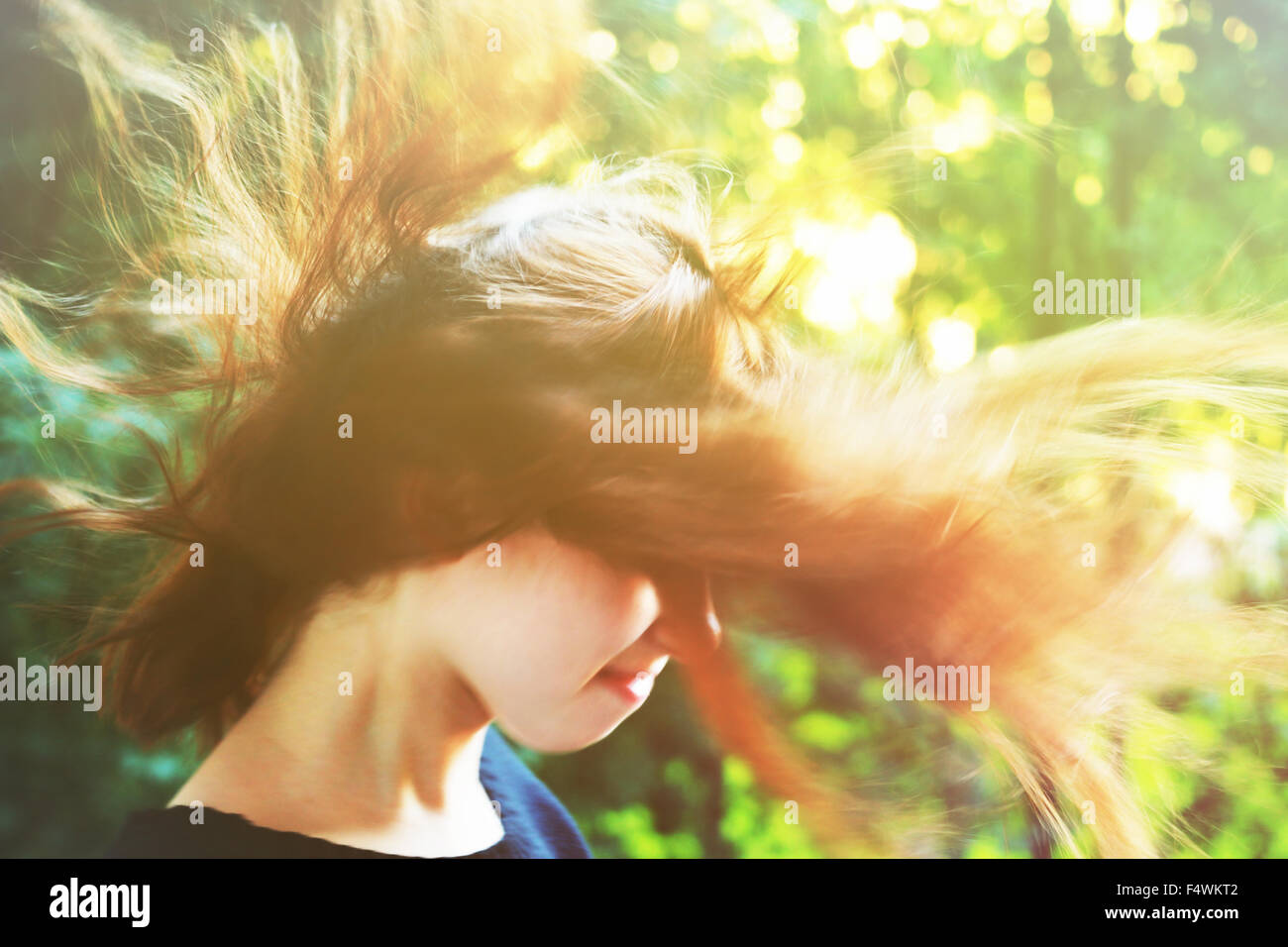 Young girl with long hair standing on strong wind. Soft focus. Stock Photo