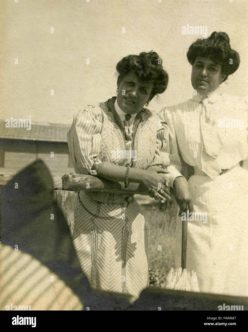 Two women dressed in white with typical hairstyle of the beginning of the XX century, Italy Stock Photo