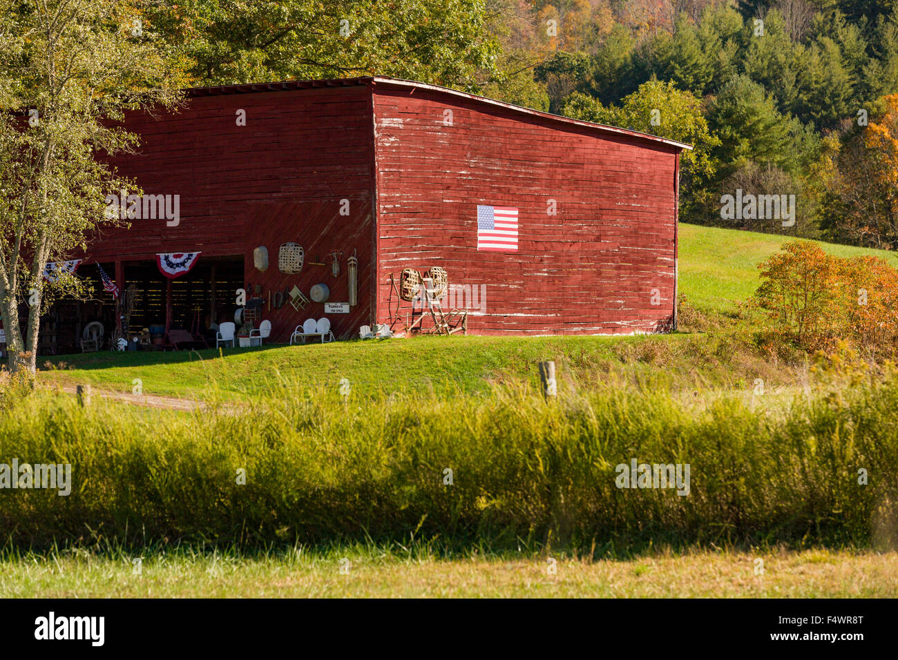 An old wooden barn decorated with an American flag on the Quilt Trails in Prices Creek, North Carolina. The quilt trails honor handmade quilt designs of the rural Appalachian region. Stock Photo