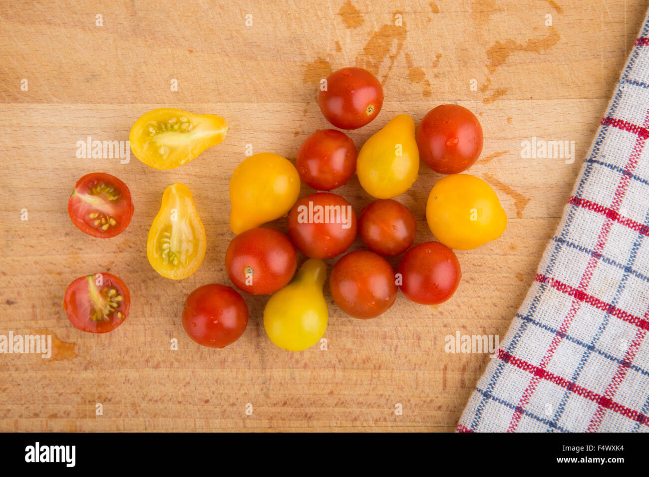 Red and yellow cherry tomatoes on a wooden cutting board Stock Photo ...