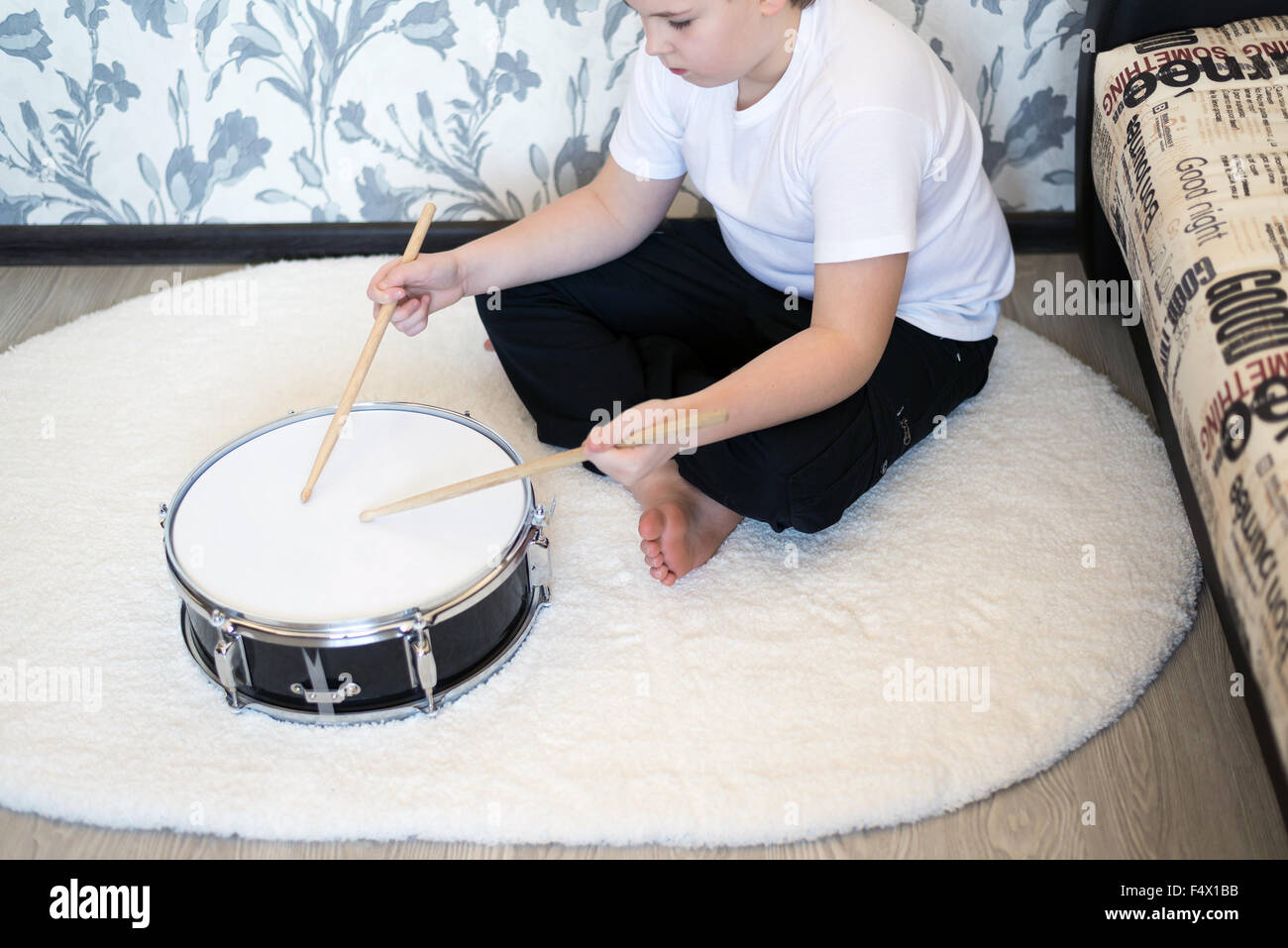 Boy teenager playing drums in  room Stock Photo